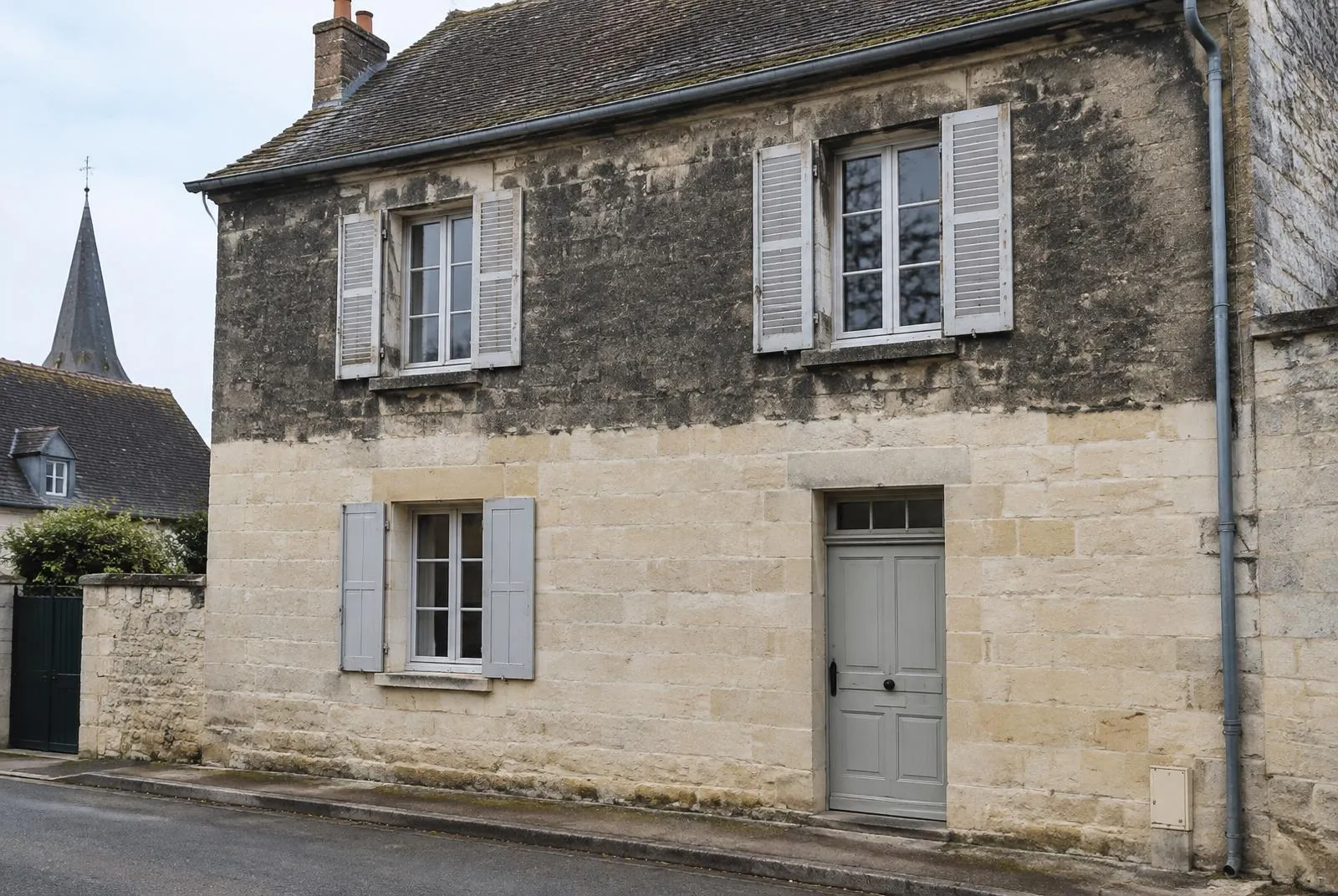 Façade en pierre calcaire : partie haute encrassée, partie basse nettoyée